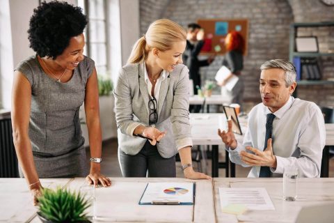 Business people analyzing reports communicating while working together